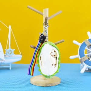 Close-up of a plush durian keychain featuring smiling fruit faces and a vibrant rainbow strap.