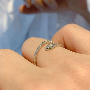 Silver snake open ring with green stone eyes and clear crystals on a polished metal band