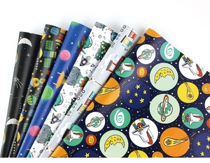 Detail of assorted space-themed wrapping paper featuring rockets and astronauts