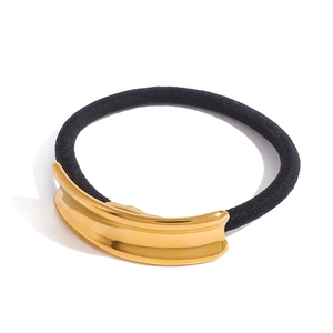 Black elastic ponytail holder with a polished gold curved metal accent on white background