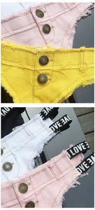 Detail der Denim-Shorts mit Metallknöpfen und elastischem LOVE-Print-Bund