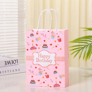 Close-up of pink birthday gift bag with cute cake patterns and Happy Birthday text
