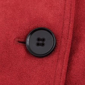 Macro detail of red faux suede fabric with a black button and fine stitching quality