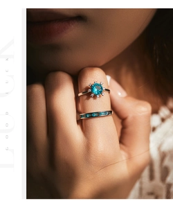 Close-up of S925 silver rings set with blue gemstone cluster and baguette stones