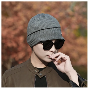 Detail of grey ribbed knit beanie with black stripe showing warm winter texture