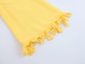 Detail of yellow V-neck dress showing delicate floral lace trim on sleeve and chiffon texture