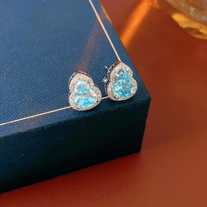 Detailed close-up of blue zircon gourd earrings on a jewelry box with soft lighting