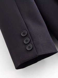 Macro shot of dark navy blazer cuffs featuring three matching resin buttons and woven texture