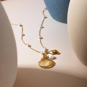 Détail du pendentif coquillage et étoile de mer doré 18k avec chaîne en perles