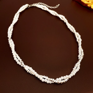 Detail of double-strand twisted necklace with white pearls and silver faceted beads