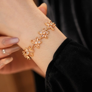 Makroaufnahme der goldenen Blumenarmband-Anhänger mit eingelegten Zirkonia-Steinen