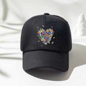 Dettaglio della stampa a cuore con farfalle su un cappello da baseball nero