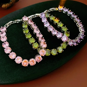 Detailed macro view of colorful round zircon tennis bracelets on green velvet stand