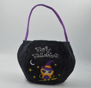 Detail of plush black Halloween candy bag with purple handle and owl embroidery