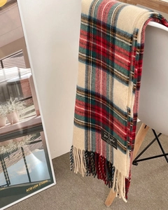 Detail of red and beige tartan scarf with wool-touch texture and fringe on white chair