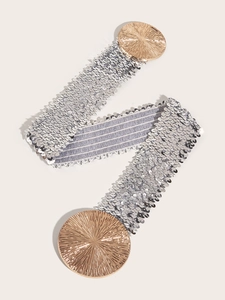 Detail of silver sequin elastic waist belt with textured gold circular buckle for dresses