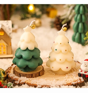 Detailed view of green and white mini Christmas tree candles with golden bell ornaments