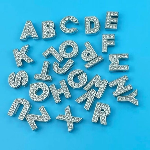 Detailed close-up of shiny A-Z silver alloy rhinestone letter charms for DIY bracelets