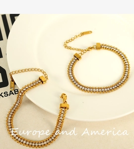 Detail of gold chain bracelet with embedded zircons and K18D engraved tag