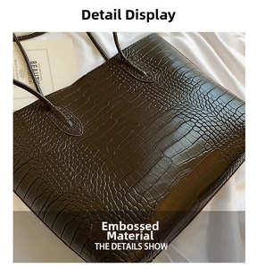 Close-up of a large coffee-brown tote bag featuring premium crocodile embossed texture