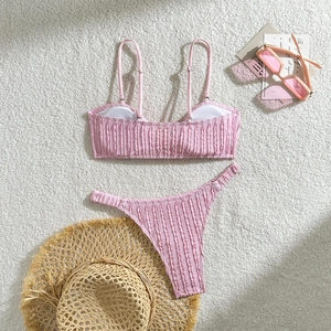 Flachbild des rosa gerippten Bikini-Sets mit dünnen Trägern und weißem Plüschhintergrund