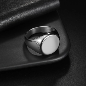 Polished silver stainless steel signet ring with a round flat face and a minimalist design