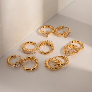 Macro view of four pairs of 18k gold-plated earrings with various zircon stone settings