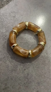 Macro detail of amber acrylic beads with marble texture and golden metal spacers
