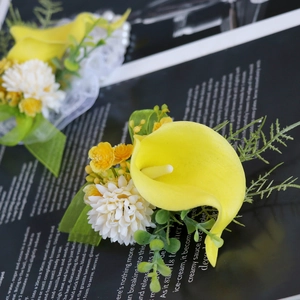 Wedding boutonniere with yellow calla lily, white daisy and green eucalyptus leaves