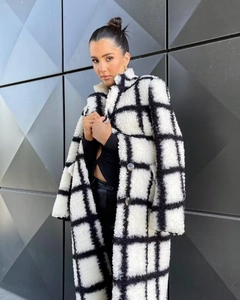 Close-up of fluffy black and white checkered faux fur fabric with textured plush grain