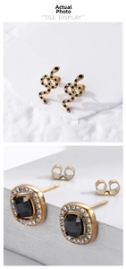 Detail of luxury snake earring and square black gemstone stud with clear crystal borders