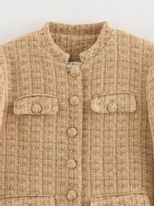 Detail of tweed jacket with gold threads, round neck, and flap pockets in champagne gold