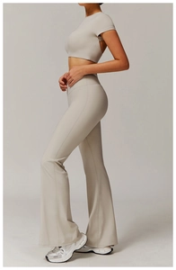Close-up of light grey high-waist flared yoga trousers and matching slim fit crop top