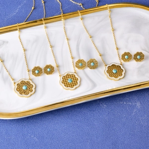 Golden mandala flower jewelry set with blue gemstones and earrings on marble tray