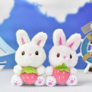 Close-up of cute plush bunny keychains holding a strawberry ornament