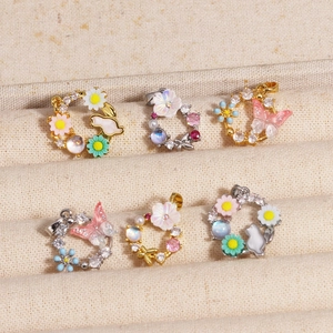 Detailed macro view of colorful zircon flower and butterfly pendants in gold and silver
