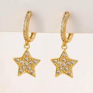 Close-up of golden star drop earrings featuring pavé cubic zirconia inlay details