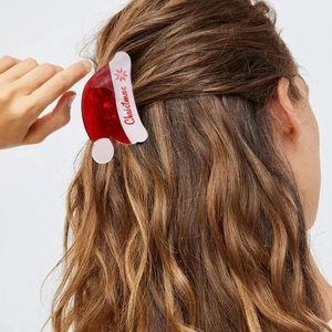 Detailed side view of Christmas hat hair claw clip on model's hair with snowflake design