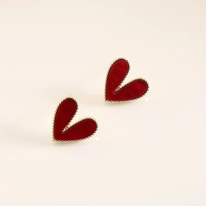 Macro shot of minimalist red heart earrings with golden beaded border on s925 silver pins