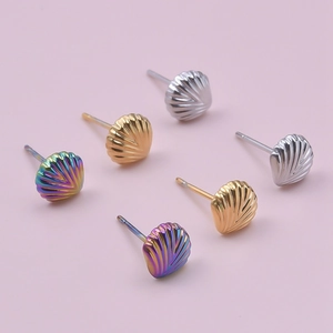 Detailed macro view of scallop shell earrings in gold, silver, and iridescent finishes