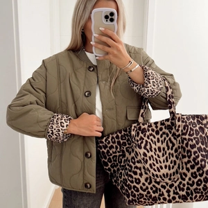 Army green quilted jacket with button closure and leopard print tote bag for casual wear