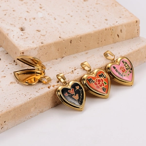 Vue macro de pendentifs médaillons cœur dorés avec émail coloré et gravures florales