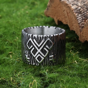 Detail of vintage silver stainless steel viking ring with bark texture on green moss