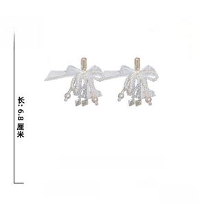 Détail des boucles d'oreilles nœud en dentelle avec perles et tiges en argent 925