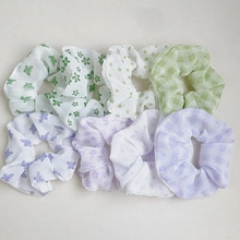 Flat lay of multiple floral and checkered knot headbands in green and purple fabrics