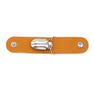 Detail eines orangefarbenen PU-Leder-Hutclips mit silberner Metallschnalle für Gepäck