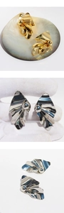 Detail view of irregular wrinkled gold and silver metallic earrings with center bead
