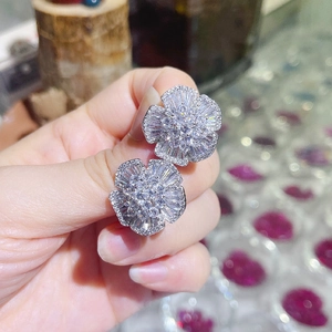 Macro detail of camellia flower earrings with sparkling cubic zirconia in silver finish