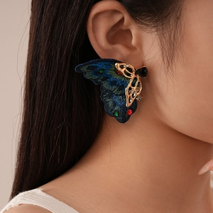 Détail de boucle d'oreille aile de papillon rétro avec broderie et strass incrustés
