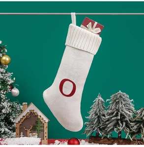 Detailed close-up of a white knitted Christmas stocking with a red embroidered letter O